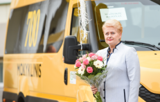 Prezidentė šalia vieno padovanoto geltonojo autobusiuko. Nuotr. prezidentas.lt