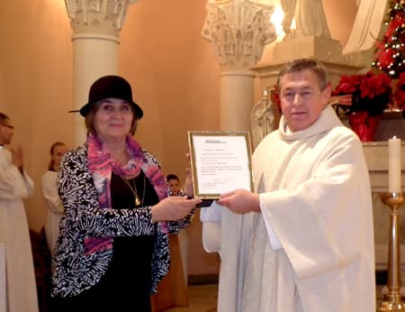 Kun. Jauniui Kelpšai „Metų žmogaus” apdovanojimą įteikia „Bičiulystės” vyr.redaktorė Ligija Tautkuvienė. Stefos Tamoševičienės nuotr.
