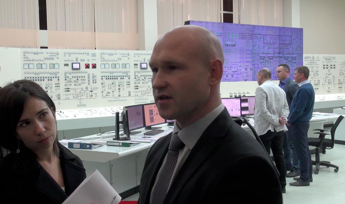 Kadras iš Baltarusijos atominės elektrinės mokomosios centrinio valdymo pulto patalpos. Į Vengrijos žurnalistės klausimą atsako elektrinės specialistas. Nuotr. E.eu