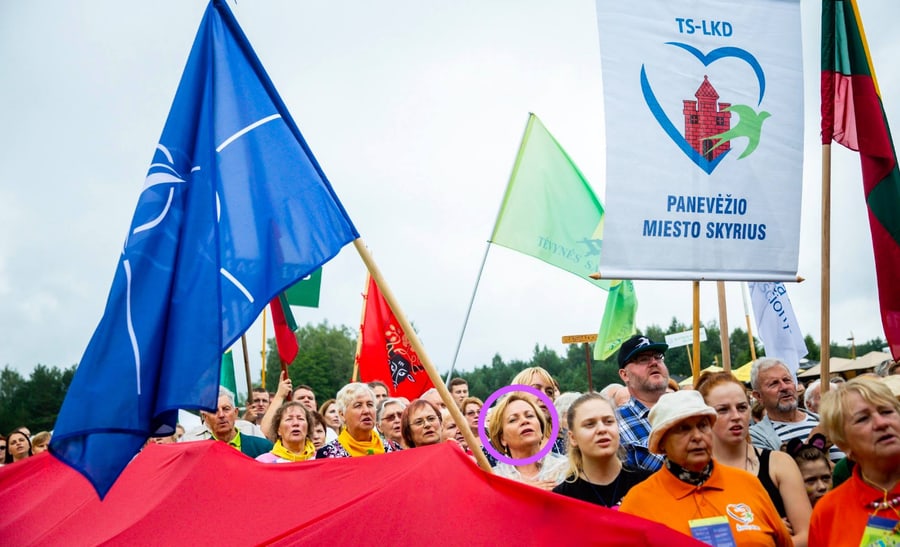 R. Juknevičienė (galvutė pažymėta violetiniu apskritimu) savo rankose laikanti NATO vėliavos kotą. Nuotr. facebook.com