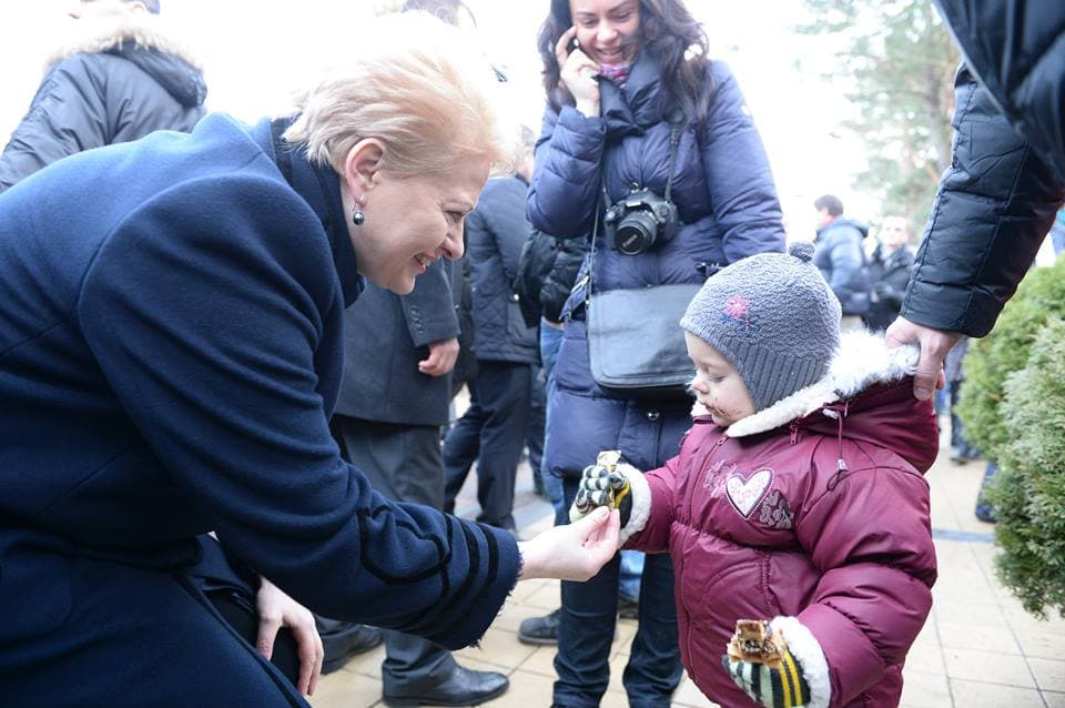 Prezidentė stintų kepimo šventėje nepaliko be dėmesio ir mažų vaikučių. Nuotr. facebook.com