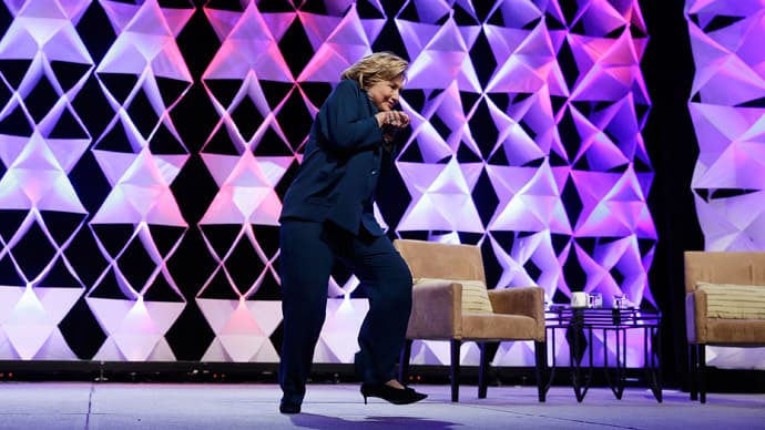 Į Hillary Clinton, kalbėjusią Atliekų perdirbimo pramonės instituto suvažiavime Mandalajaus įlankos viešbutyje, skrido juodai oranžinis „Puma“ firmos gamintas batas