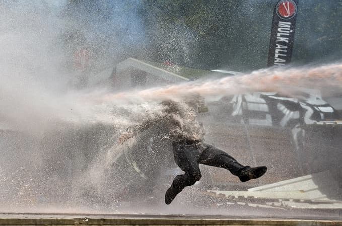 Paveiktas vandens patrankos žmogus akimirkai gali pajusti lengvą nesvarumo būseną, todėl noras protestuoti kuriam laikui nuslopsta. Nuotr. aljazeera.com