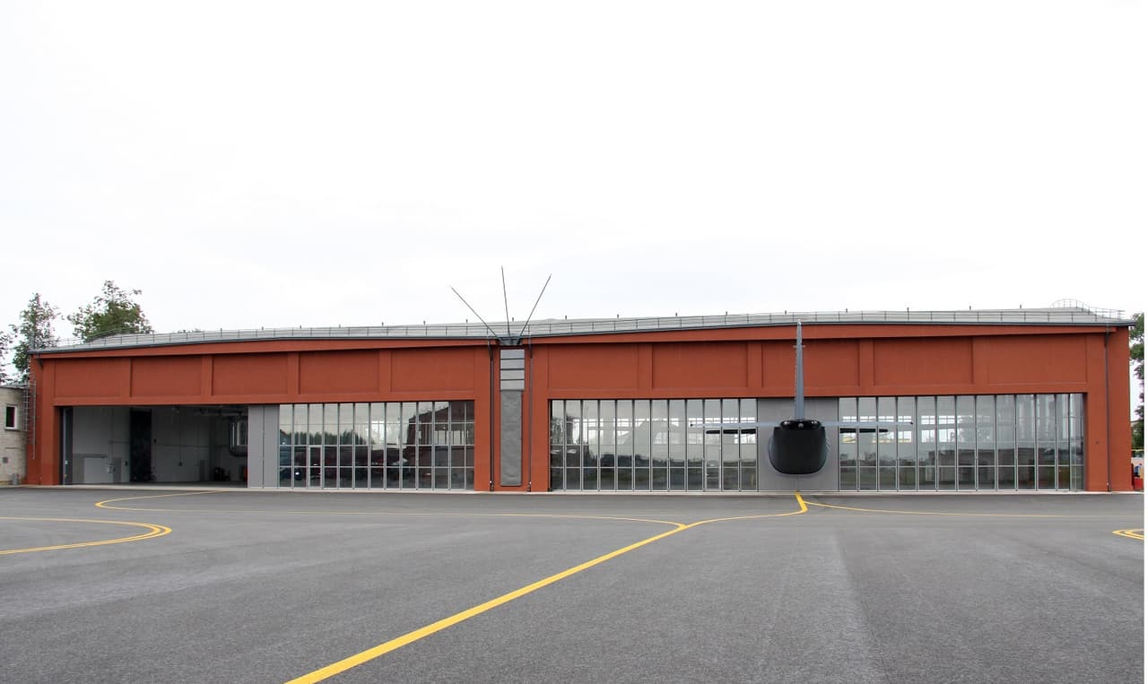 KOP AB nuotr. Vienas iš naujųjų KOP Aviacijos bazės infrastruktūros objektų – istorinio Antano Gustaičio angaro, kuriame tarpukariu buvo surenkami lietuviški lėktuvai ANBO, rekonstrukcija. Rekonstrukcijos metu buvo pakeisti senieji angaro vartai, sutvarkytos angaro šildymo ir vėdinimo sistemos. Šiuo metu A. Gustaičio angaras išlieka ne tik istorine Lietuvos aviacijai vieta, bet ir yra aktyviai naudojamas Lietuvos karinių orlaivių techniniam aptarnavimui.